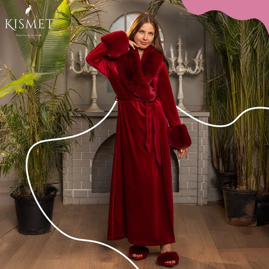 Woman in a red robe standing in a room with plants and a fireplace, with 'KISMET' branding.